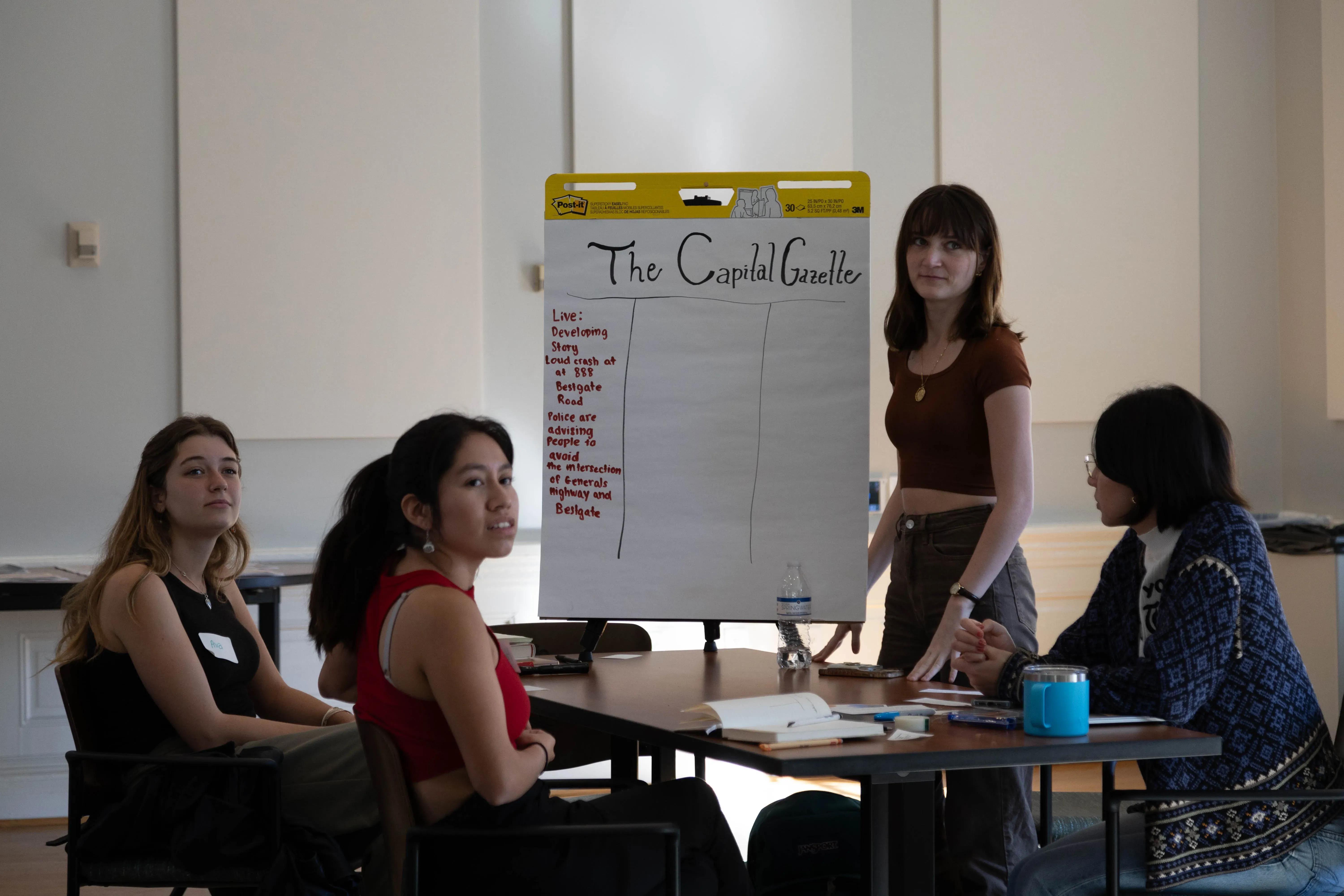 Ava Echard '25, Haidyn Brockelman '26, Logan Mischke '26, and Alex Nakamitsu '26 (left to right) collaborate in a newsroom simulation in Denise Watson's masterclass last October in the Grimsley Boardroom